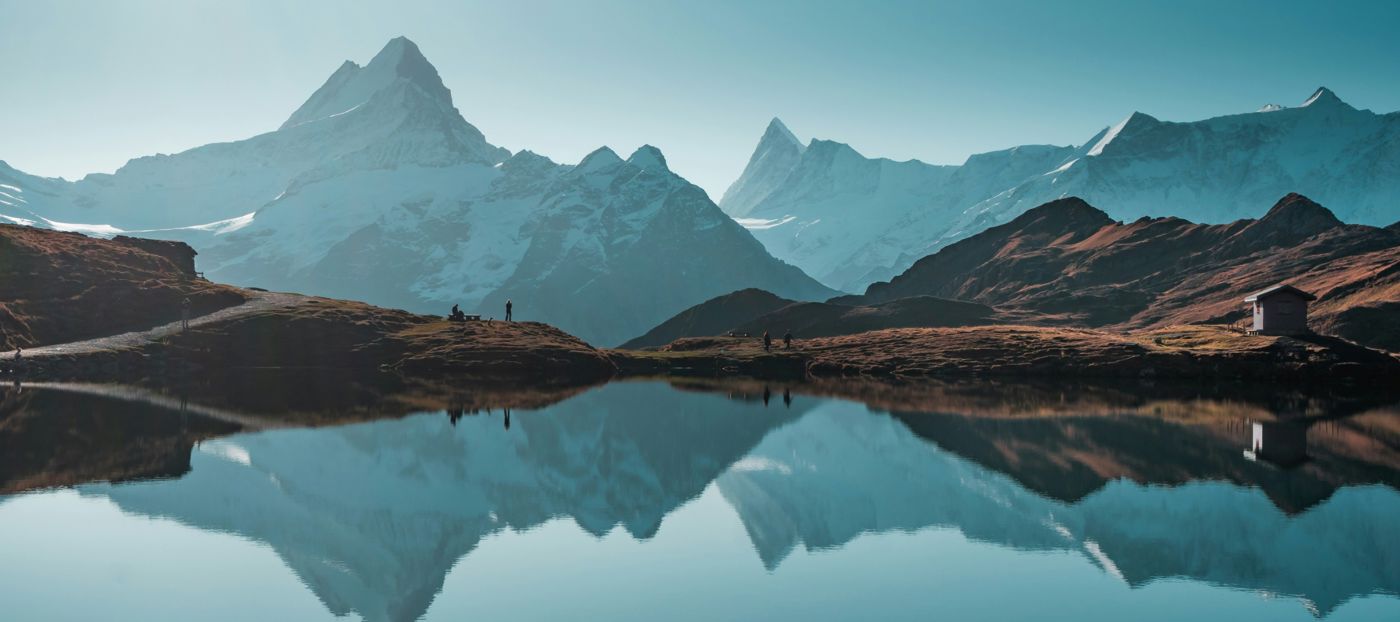 Calm lake with mountain tops reflected in the water surface.