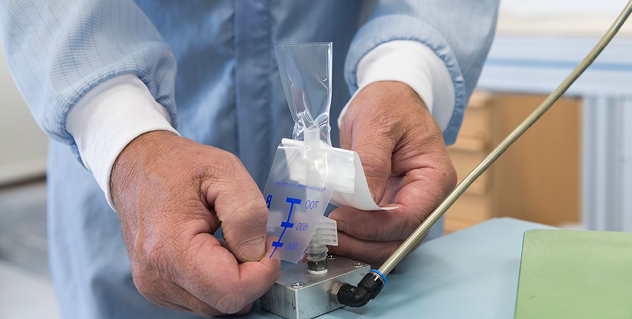 Hands testing a plastic valve.