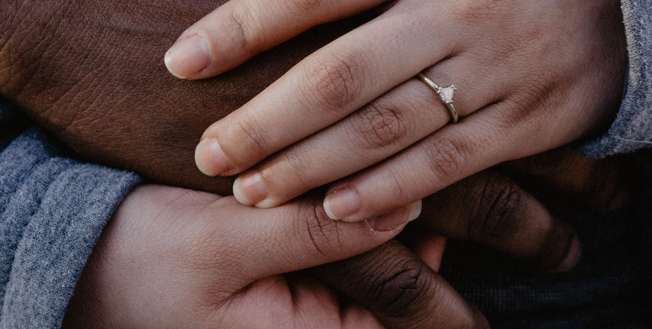 Closeup of hands embracing.